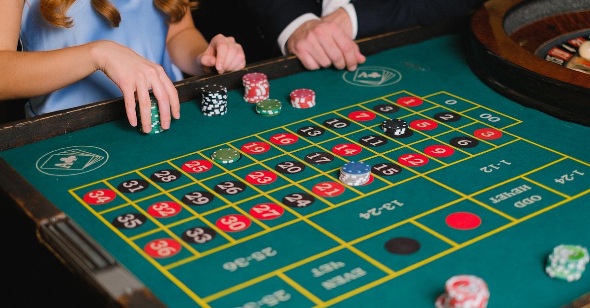 Captivating scene of a casino roulette table with gamblers placing their bets.